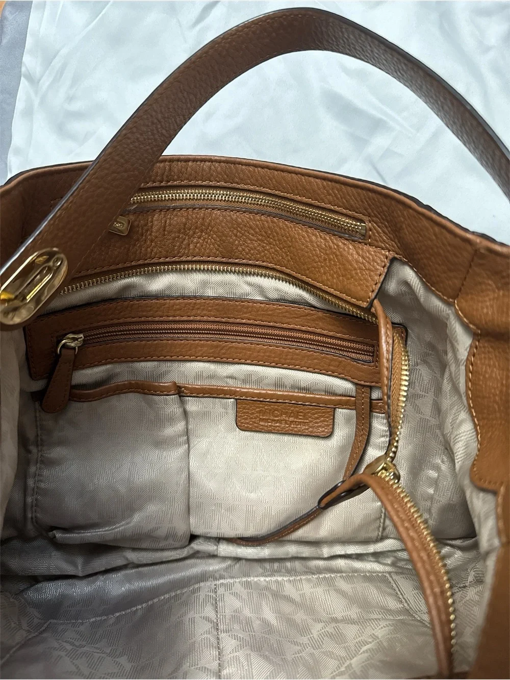 Michael Kors Cognac Pebbled Leather Shoulder Bag with Gold logo on the side.